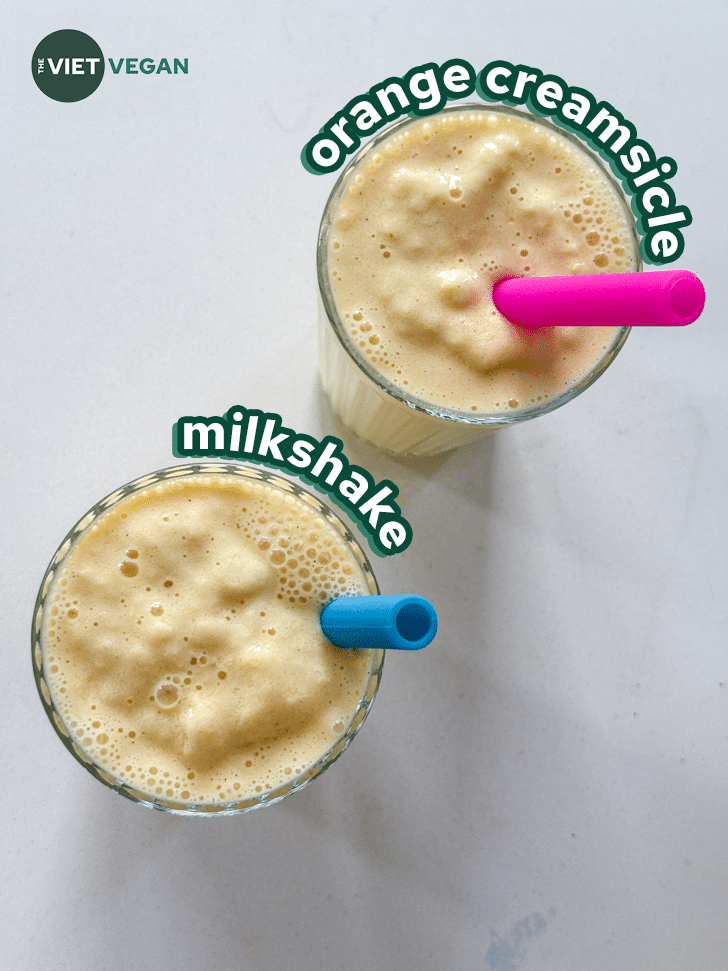 vegan orange cream milkshake in two glasses with colourful silicone straws